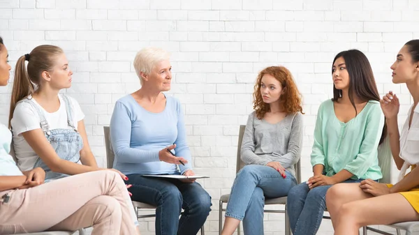 Professorspsykoterapeut pratar med kvinnor under sessionen sitter inomhus, Panorama — Stockfoto