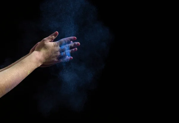 Mãos batem palmas com tinta azul no fundo preto — Fotografia de Stock