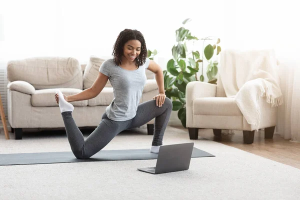 Training op isolatie. Sportieve vrouw oefenen Yoga in de voorkant van laptop — Stockfoto