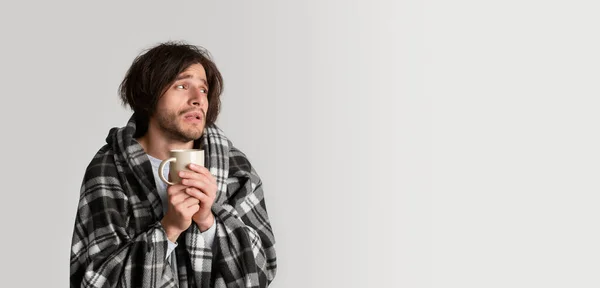 Mann hält Becher mit Heißgetränk in der Hand und blickt auf leeren Platz — Stockfoto