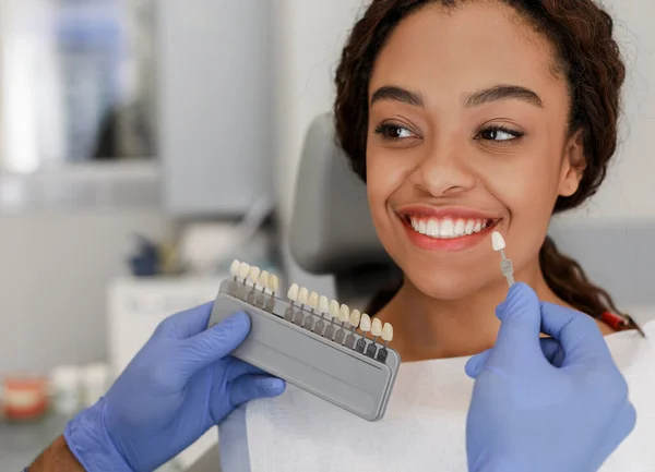 Dentista aplicando amostra da escala de dentes aos dentes do paciente — Fotografia de Stock