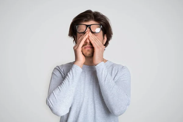 Migraine en oogpijn. Kerel heft bril — Stockfoto