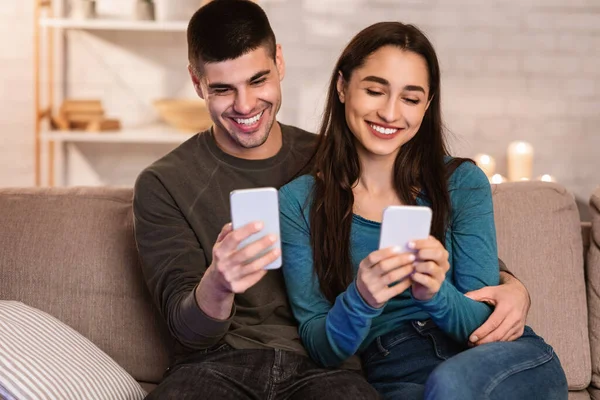 Paar met mobiele telefoon zittend op de bank, vrije ruimte — Stockfoto