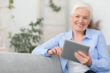 Gülümseyen son sınıf güzeli evde dijital tablet kullanıyor, boş alan, kapat