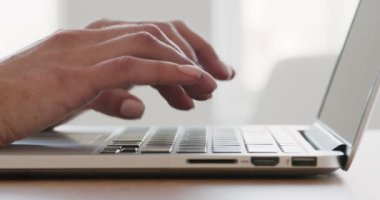 Dizüstü bilgisayarda yazı yazan genç kadın elleri.