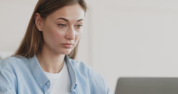 Jonge vrouw werkt op afstand op laptop op kantoor — Stockvideo