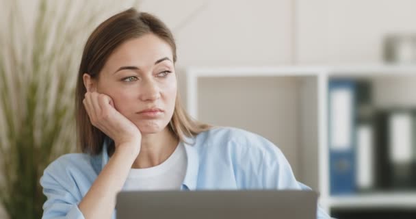 Femme paresseuse ennuyée assise au bureau et travaillant avec un ordinateur portable — Video