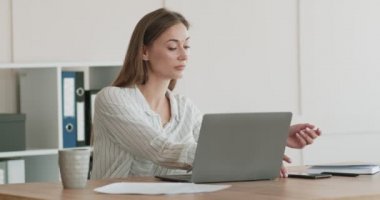 Dost canlısı iş kadını telefonda konuşuyor, bilgisayarla çalışıyor.