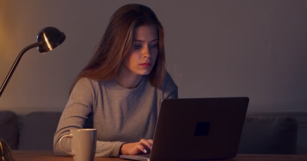 Jeune étudiante étudiant avec ordinateur portable à la maison tard dans la soirée — Video
