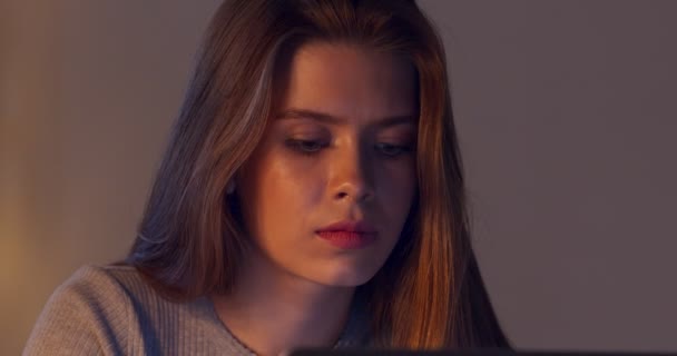 Портрет молодої зосередженої жінки, яка працює вдома пізно ввечері — стокове відео