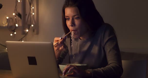 Femme pigiste manger de la nourriture chinoise, réseautage sur ordinateur portable tard — Video
