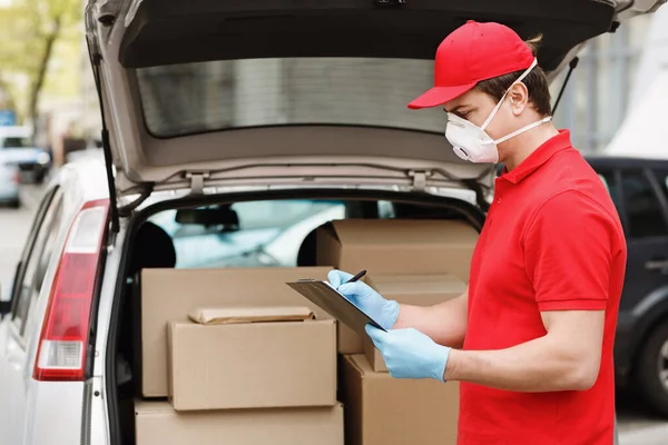 Pengiriman pria dekat mobil dengan bagasi terbuka dengan paket — Stok Foto