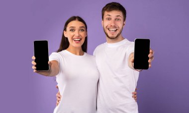 Kameraya boş cep telefonu ekranı gösteren mutlu çift
