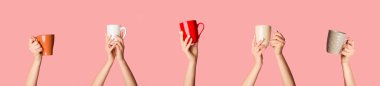 Kadın eli ile kolaj farklı bardakları tutuyor pembe arka planda sıcak içecekler, yakın plan. Panorama