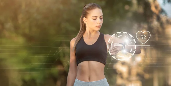 Menina desportiva bonita olhando para relógio inteligente — Fotografia de Stock