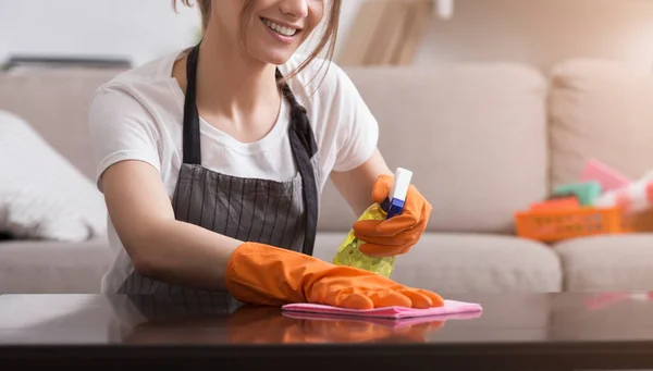 Camarera profesional. Primer plano de la mesa de limpieza de mujer joven de polvo —  Fotos de Stock