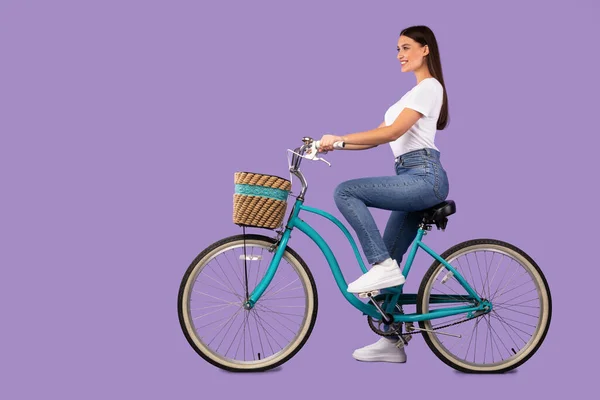 Красива жінка їде на велосипеді в студії, ізольована — стокове фото