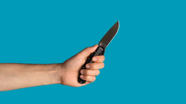 Primo piano del giovane ragazzo con in mano un coltello da tasca su sfondo blu, spazio vuoto. Panorama — Foto Stock