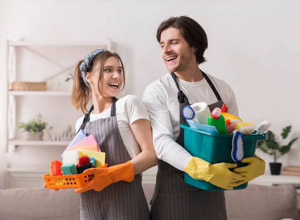 Happy Couple Holding emmers met huishoudelijke benodigdheden, klaar voor de lente schoonmaak — Stockfoto