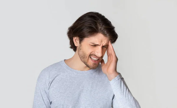 Jonge mooie man met hoofdpijn of migraine — Stockfoto