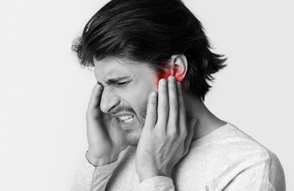 L'homme a mal aux oreilles. Toucher avec les mains sa tête douloureuse — Photo