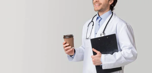 Felismerhetetlen férfi orvos gazdaság orvosi karton és ivás Takeaway kávé — Stock Fotó