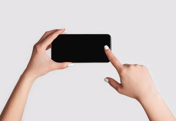 Closeup of woman touching mobile phone with blank screen on light background, copy space — Stock Photo, Image