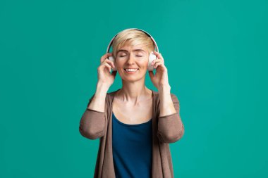 Kablosuz kulaklıklı, gülümseyen kadın.
