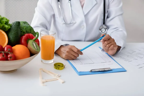 Cropped of african female nutritionist filling medical form — Stock Photo, Image