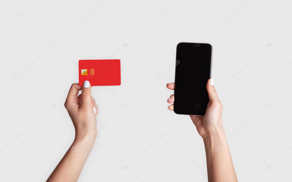 Internet shopping. Girl holdng credit card and mobile phone with blank screen on light background, mockup for design