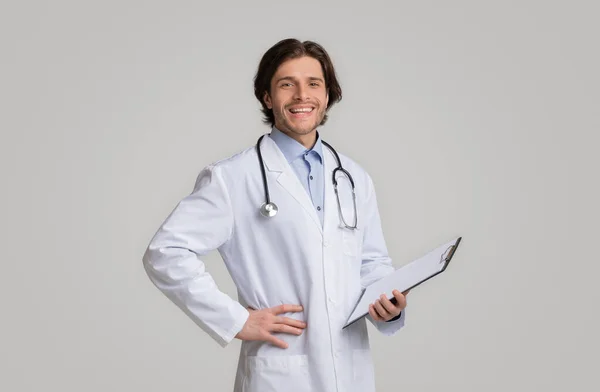 Especialista médico no revestimento branco e no estetoscópio que prendem a prancheta com prescrições — Fotografia de Stock