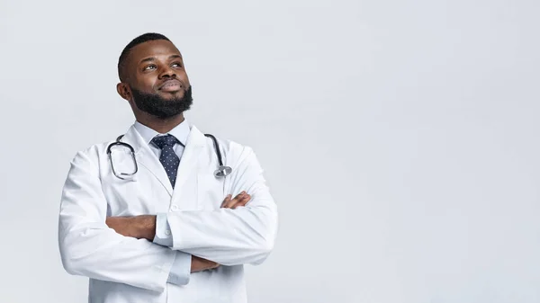 Happy medical doctor in white robe looking at copy space — Stock Photo, Image