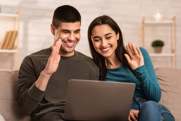 Feliz casal encantador fazendo chamada de vídeo no laptop em quarentena — Fotografia de Stock