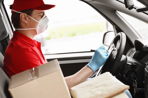 Correio em carro escreve para tablet, perto de caixas de papelão — Fotografia de Stock