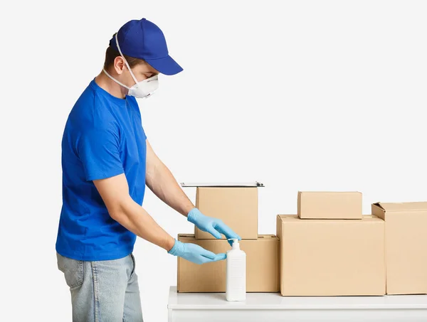 Kurier desinfiziert Hände vor Paketzustellung mit Antiseptikum — Stockfoto