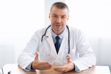 Kamerayla konuşan olgun bir doktorun portresi