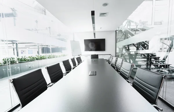 Långt bord i konferenslokal med TV, genomskinliga väggar — Stockfoto
