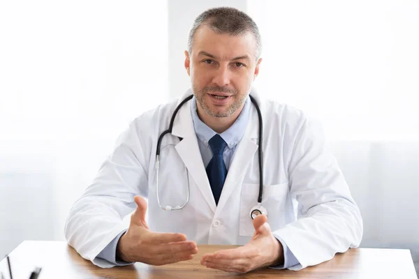 Portrait of mature doctor talking to camera — Stock Photo, Image