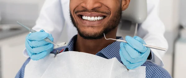 Branco sorriso masculino saudável e mãos dentista com instrumentos — Fotografia de Stock
