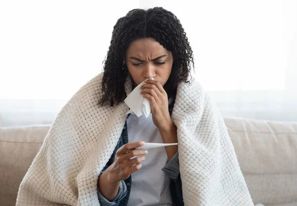 Coronavirus-Symptome. Kranke schwarze Frau überprüft ihre Körpertemperatur zu Hause — Stockfoto