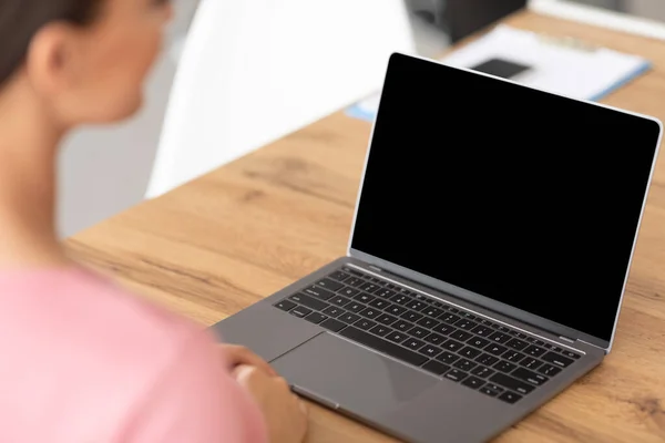 Mulher trabalhando no laptop com tela preta em branco — Fotografia de Stock