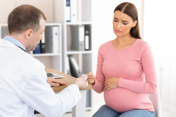 Mature experienced doctor giving pills to pregnant patient — Stock Photo, Image