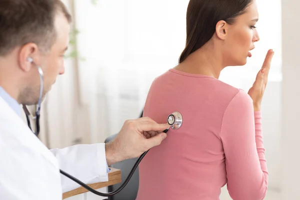 Médico experiente verificando a respiração de paciente do sexo feminino — Fotografia de Stock