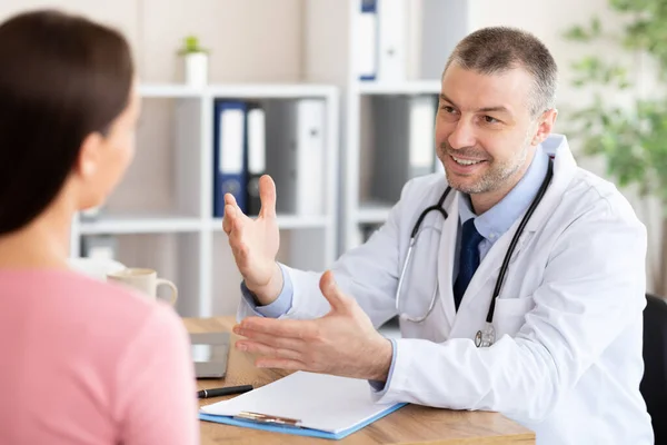 Médico experimentado maduro hablando con paciente femenino — Foto de Stock