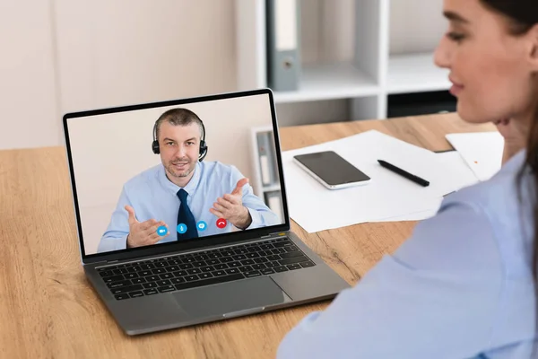 Empresária tendo reunião on-line com colega de trabalho sentado no escritório — Fotografia de Stock