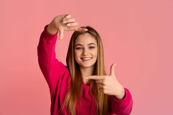 Mosolygó tinédzser lány csinál fényképet kezekkel — Stock Fotó