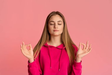 Genç kız kapalı gözlerle meditasyon yapıyor, boş alan.