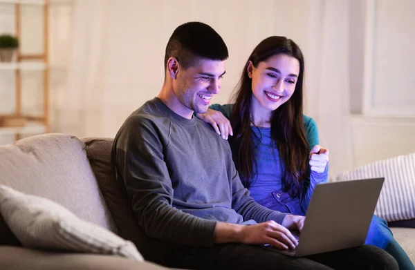 Šťastný pár pomocí PC sedí na gauči — Stock fotografie