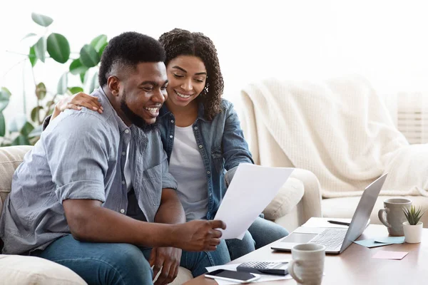 Feliz pareja negra manejando el presupuesto familiar en casa juntos —  Fotos de Stock