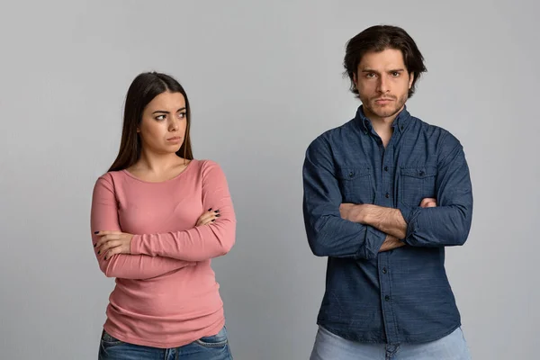 Aziatisch jong man op zoek met verdriet op zijn boos vriendin, paar vechten over grijze achtergrond — Stockfoto